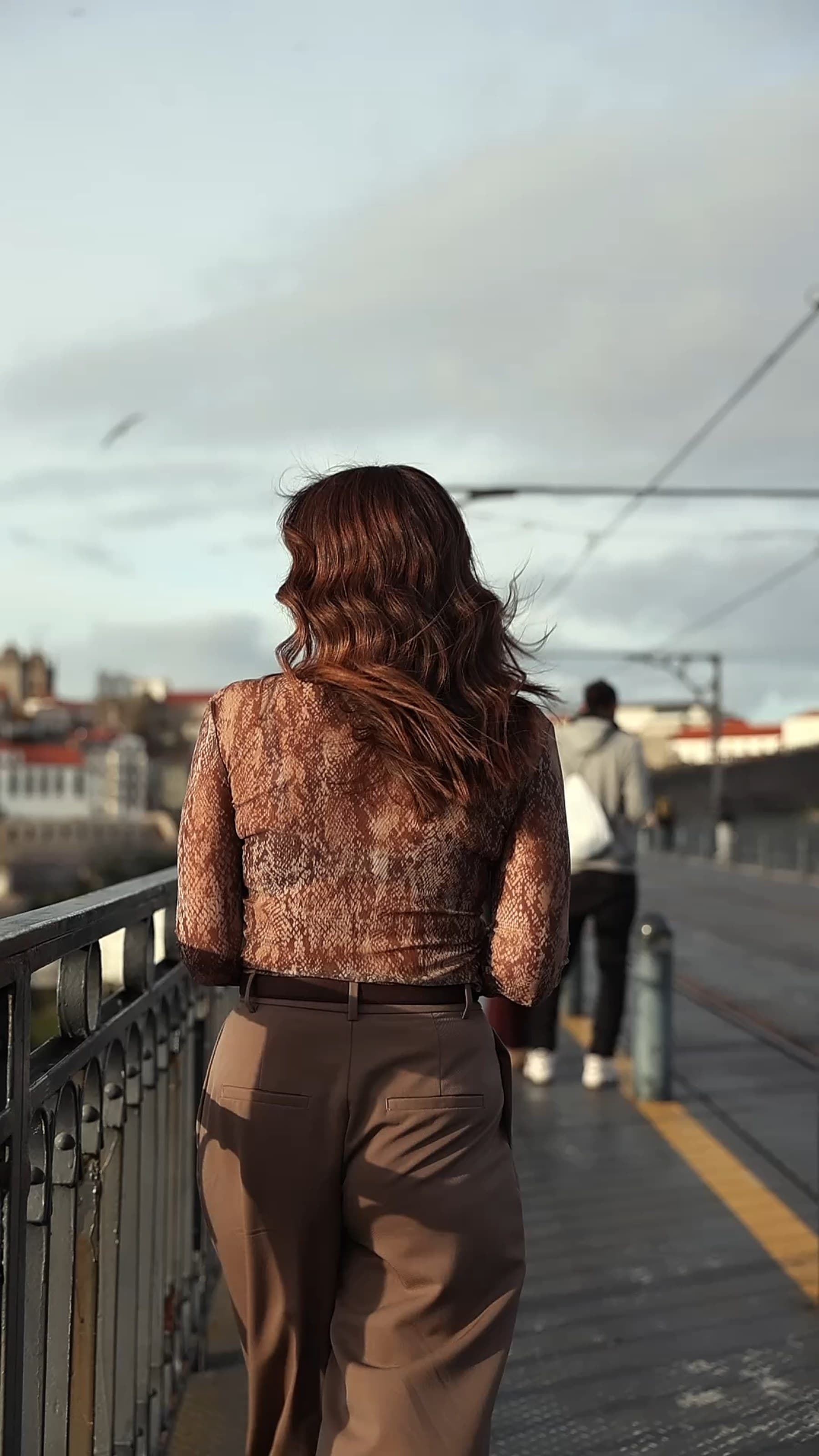 Vânia Melro de costas, a observar a cidade sobre a ponte